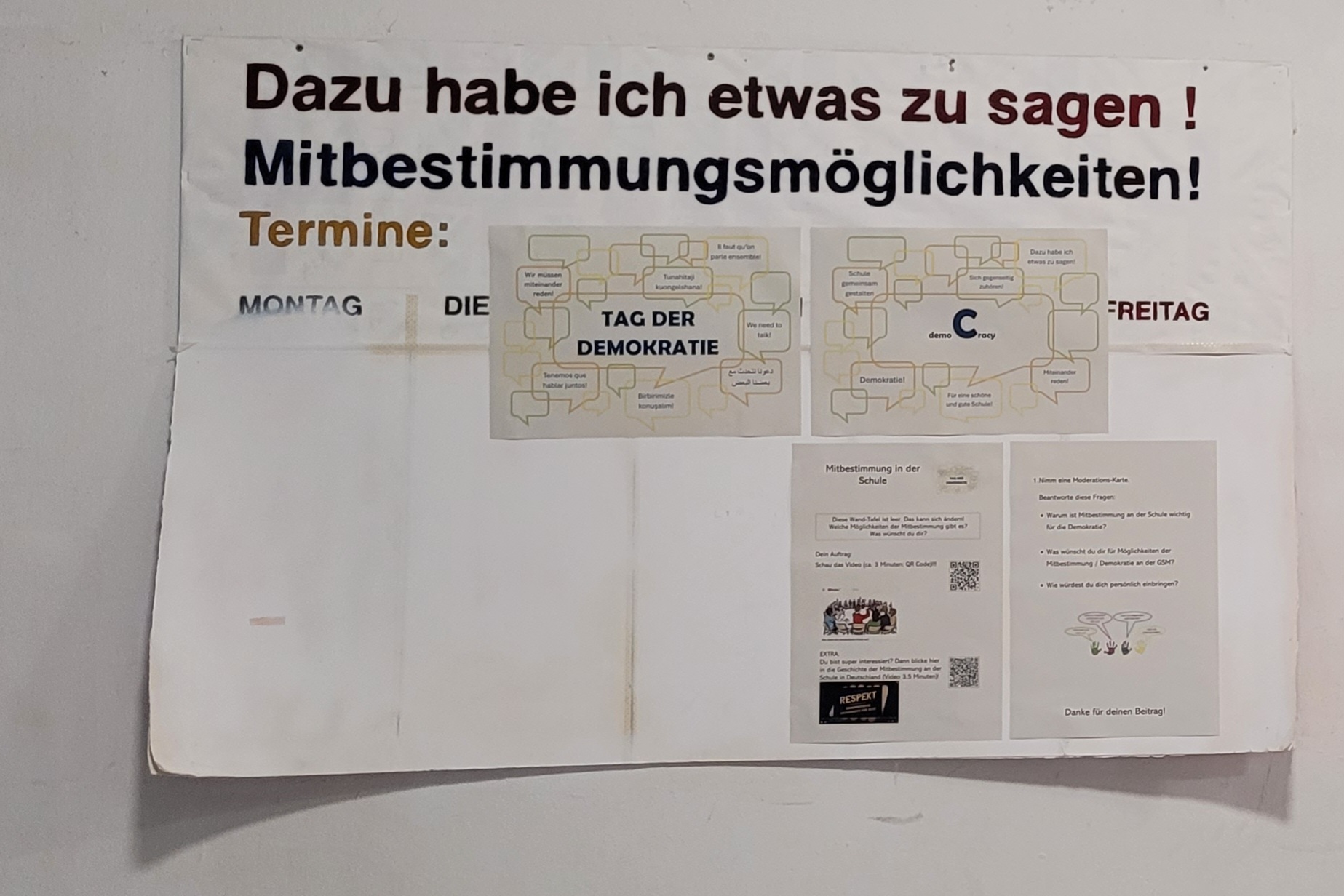 Die _Station C__ Mitbestimmung in Schule Wandtafel mit Überschrift 'Dazu habe ich etwas zu sagen! Mitbestimmungsmöglichkeiten!' und mehreren ausgedruckten Informationsblättern zur Station C des Tages der Demokratie 2025 an der Gesamtschule Bremen Mitte.